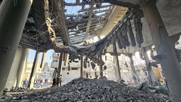 Los palestinos observan los destrozos causados por una bomba en un edificio en el norte de Gaza.