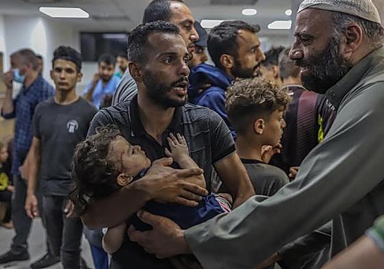 Un palestino llega a un hospital con su hijo herido durante un bombardeo.