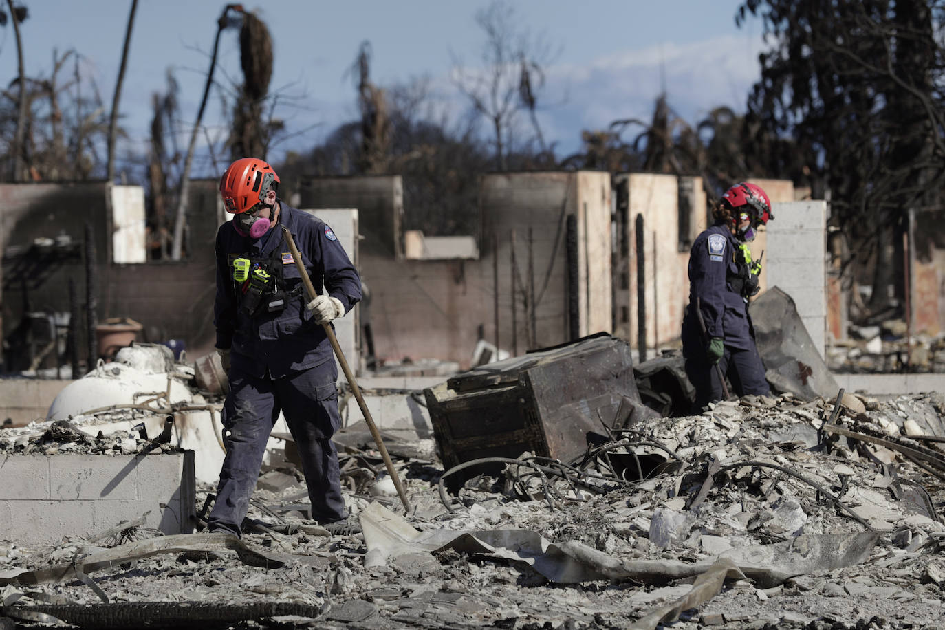 Miembros del equipo de búsqueda recorren una zona destruida de Lahaina