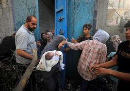 Familias palestinas huyen durante un ataque aéreo israelí en el centro de la Franja de Gaza.