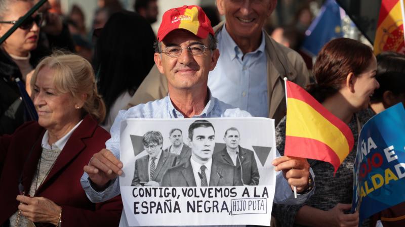 Un hombre con una pancarta contra Pedro Sánchez en la Puerta del Sol en Madrid.