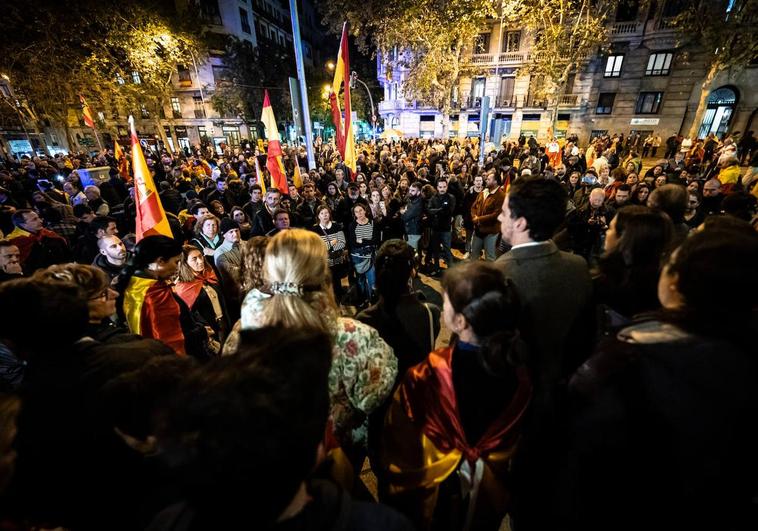 Decenas de personas con banderas y carteles durante la manifestación celebrada este lunes contra la amnistía cerca de la sede del PSOE en Madrid.