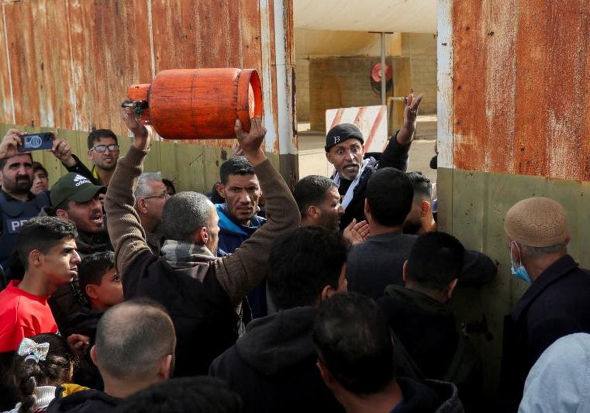 Un grupo de palestinos hacen cola en Rafah para llenar cilindros de gas durante la tregua temporal entre Hamás e Israel.