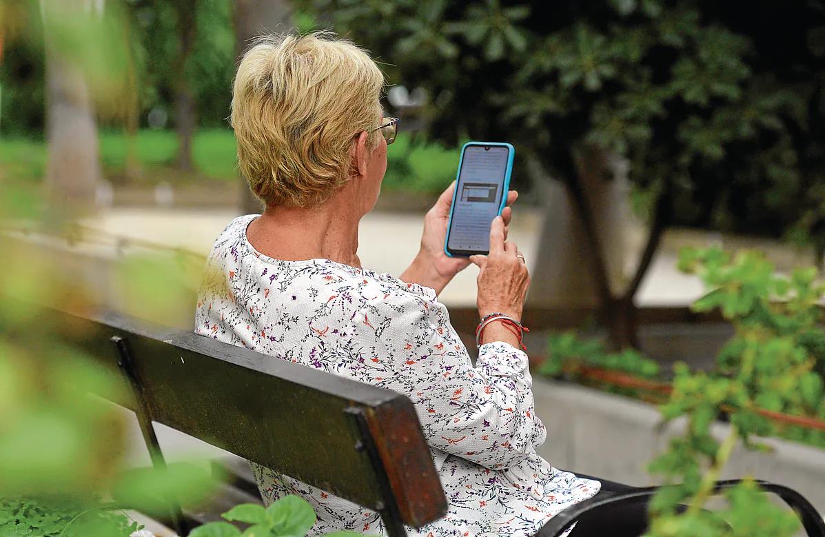 Una anciana navega con su móvil en internet.