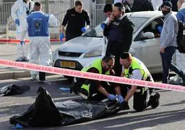 Policías recogen los cadáveres de los asesinados en Jerusalén.