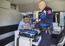 Un policía municipal de Madrid realiza una prueba con un etilómetro.