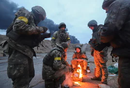 Soldados rusos tratan de calentarse en Ucrania.