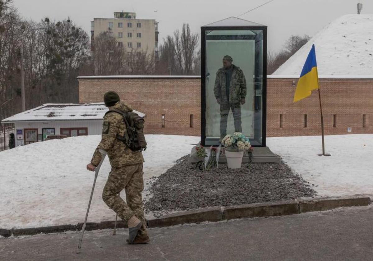 Un soldado herido en proceso de recuperación atraviesa una plaza que acoge un memorial que recuerda a los militares caídos en la guerra.