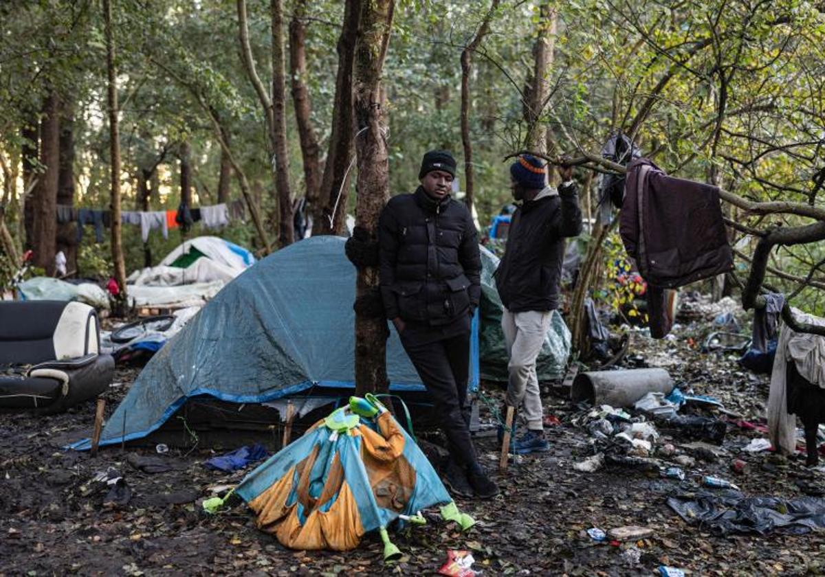 Dos migrantes sudadenes junto a sus tiendas de campaña en un campamento improvisado en la ciudad de Calais, en el norte de Francia.