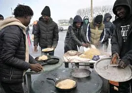 Los inmigrantes sudaneses preparan una comida típica en un campamento de refugiados en Ouistreham