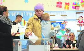 Una mujer deposita su voto en la urna de un colegio electoral de Belgrado.