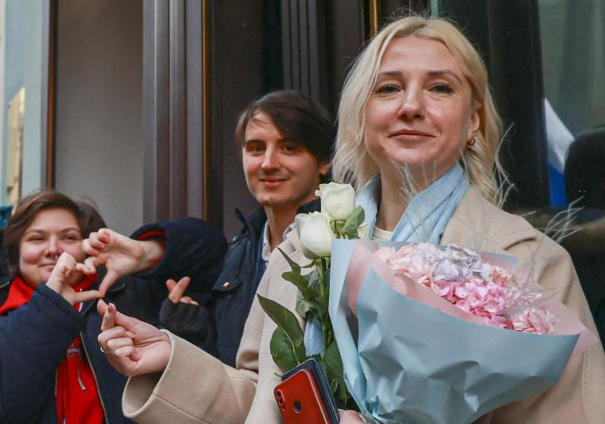 Ekaterina Duntsova sostiene flores y posa con sus partidarios frente a la Comisión Electoral Central en Moscú.