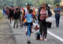 Migrantes caminan en caravana para llegar a la frontera de Estados Unidos por México, en Huixtla.