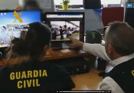 Agentes de la Guardia Civil examinan un vídeo en el que aparecen mensajes e imágenes enviados por jovenes que hacen apologia del terrorismo en internet.