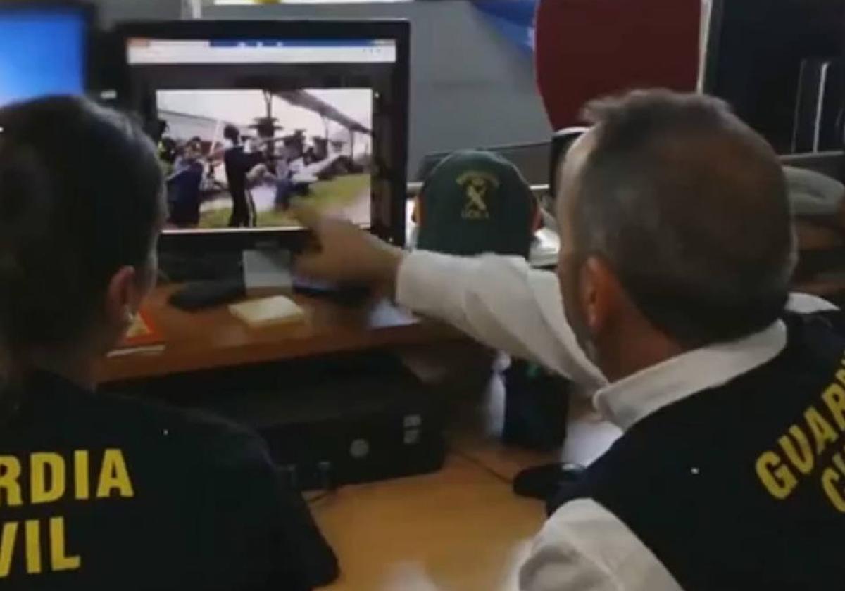 Agentes de la Guardia Civil examinan un vídeo en el que aparecen mensajes e imágenes enviados por jovenes que hacen apologia del terrorismo en internet.