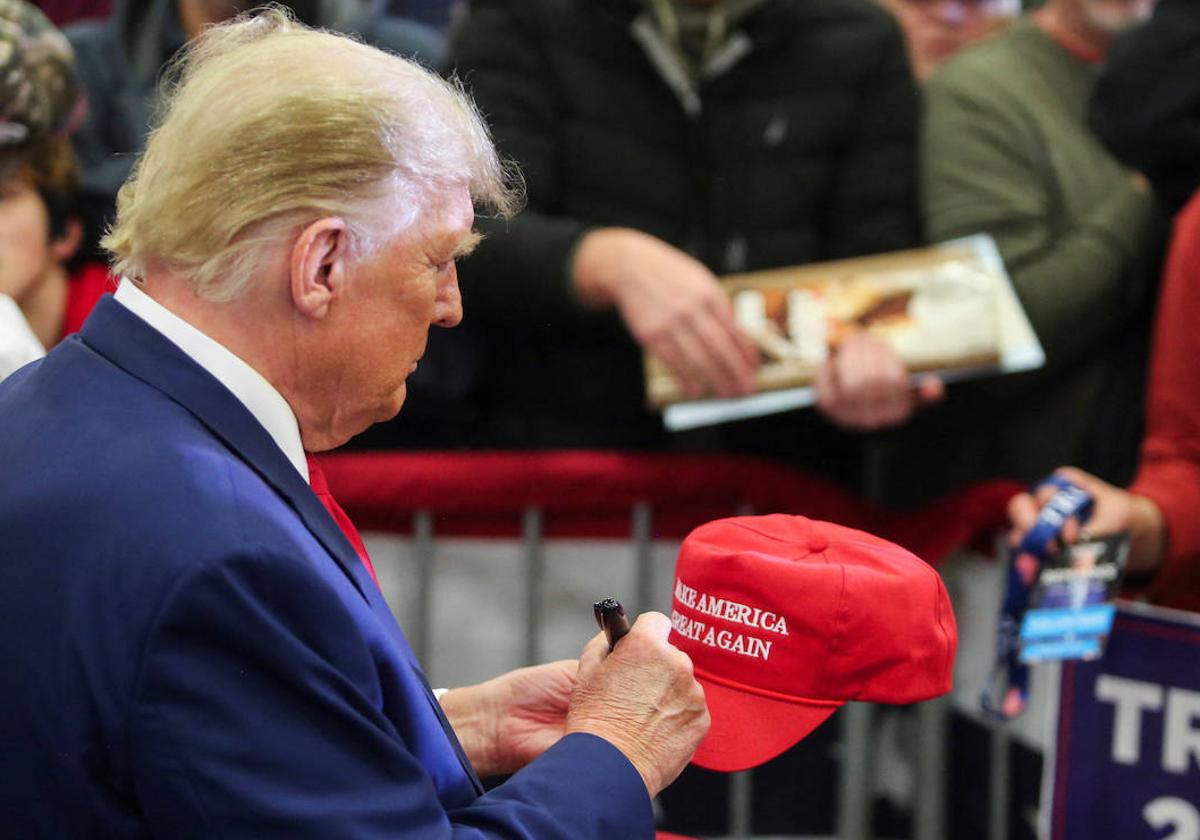 Donald Trump firma un autógrafo durante un mitín de campaña en Iowa