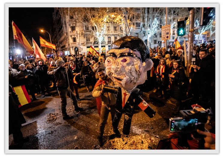 Decenas de manifestantes celebraron la Nochevieja en Ferraz e inauguraron el año golpeando un muñeco con forma de Pedro Sánchez.