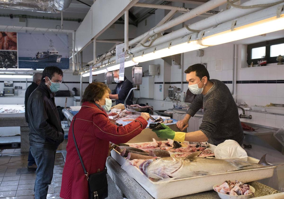 Clientes comprando en una pescadería.