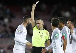 Jaime Latre amonesta a un jugador del Granada en un enfrentamiento contra el Barça.