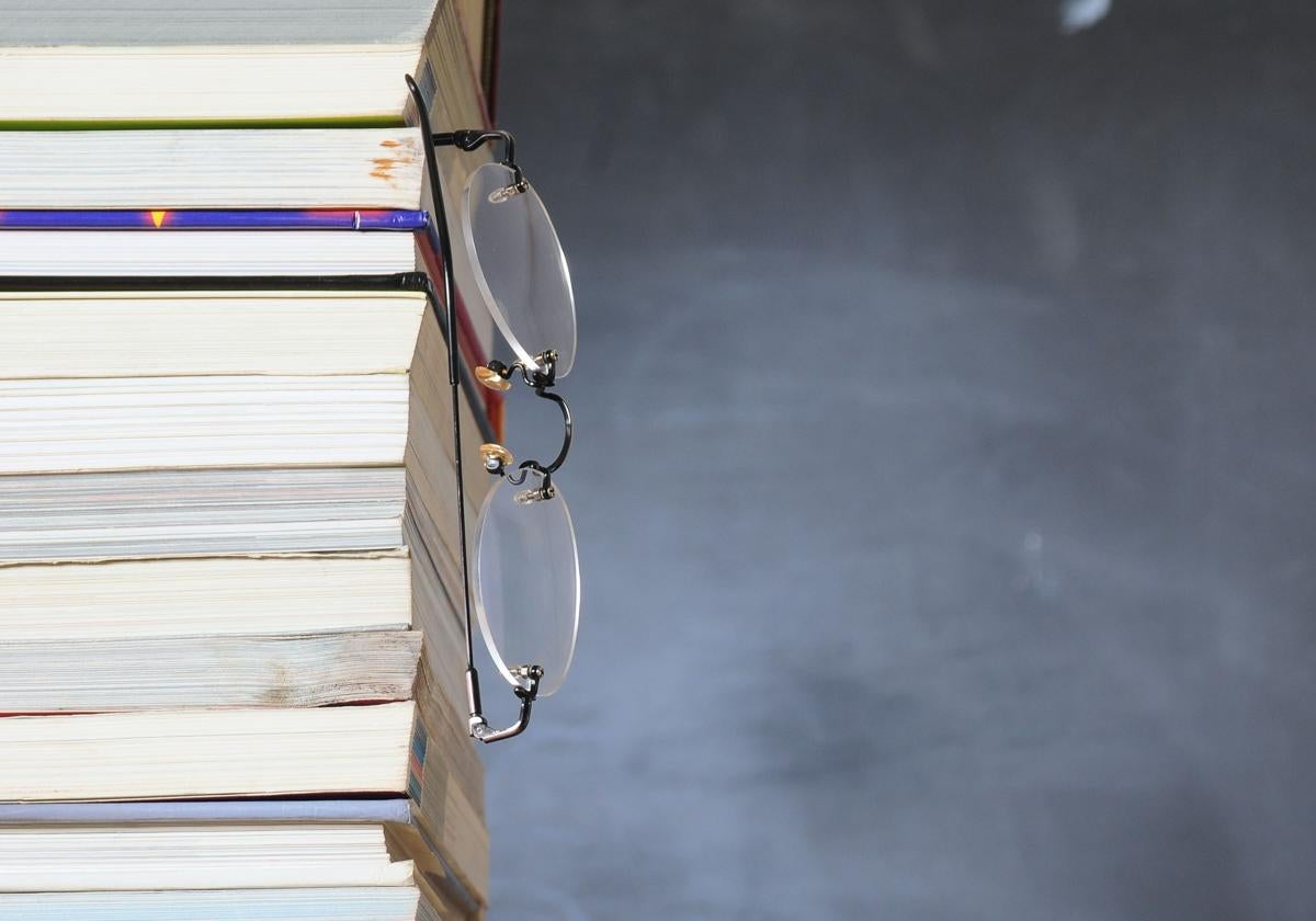 Gafa colgada de una pila de libros