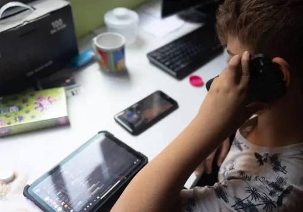 Un niño utiliza al mismo tiempo un móvil y una tablet