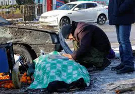 Un hombre llora a su esposa, muerta mientras trabajaba en el mercado de alimentos de Donetsk.
