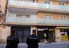 Dos policías nacionales junto al edificio donde tuvo lugar el crimen