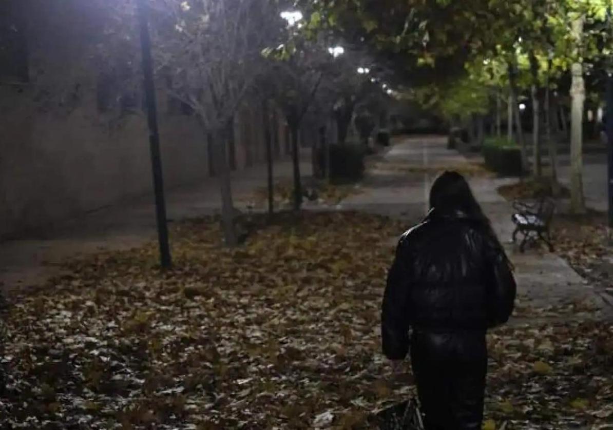 Una mujer camina por la noche.