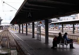 Dos pasajeros esperan en la estación central de trenes de Múnich, desierta por la huelga.