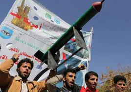 Universitarios yemeníes portan la réplica de un misil durante una manifestación de apoyo a los hutíes.