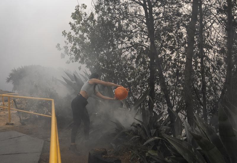 Una joven ayuda a extinguir un fuego que afecta la zona de Canal Beagle, Viña del Mar.