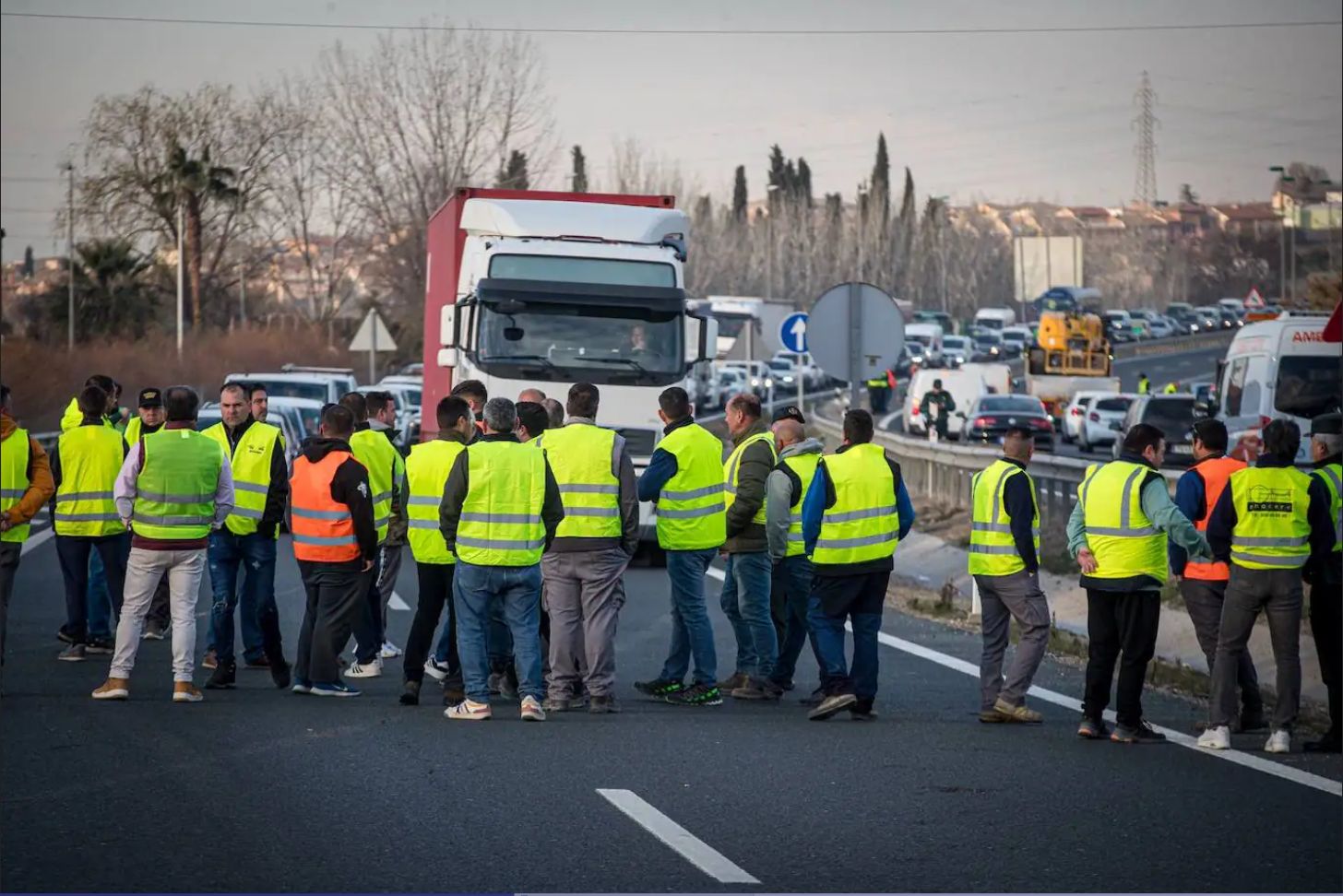 Protestas de los agricultores en la provincia de Granada en la carretera A-92. Los tractores han formado una barrera en mitad de la autovía y los agricultores a pie están en la calzada para impedir el paso del resto de vehículos.