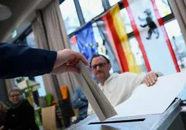 Un hombre introduce su papeleta en una urna en un colegio electoral de Berlín.