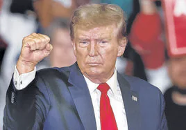 Trump realiza un gesto de fortaleza durante uno de sus últimos mítines.