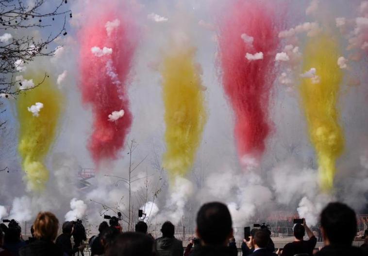 Varias personas observan el humo de colores durante la primera mascletà madrileña