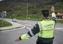 Un agente de la Guardia Civil de Tráfico manda parar a un vehículo en un control policial en Pamplona