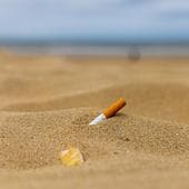 Colilla de tabaco abandonada sobre la arena.