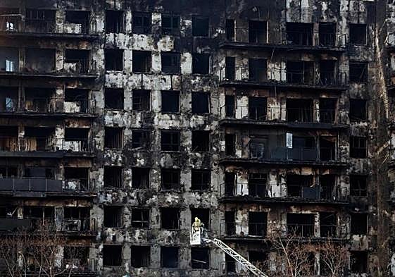 Los bomberos inspeccionan el bloque residencial arrasado por el incendio en Valencia.