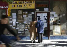 Una pareja observa las rebajas por cierre de un comercio de Madrid.