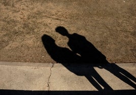 Una pareja de adolescentes charla en la calle.