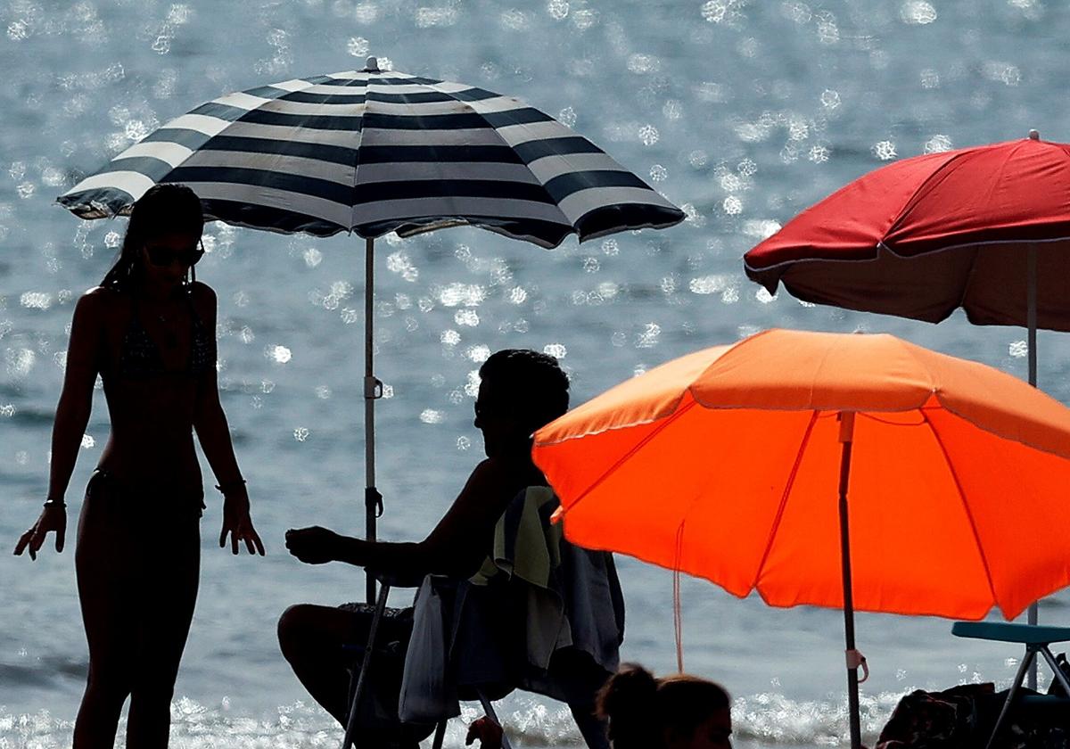 Varias personas disfrutan de la playa de la Malvarrosa.