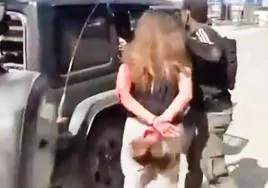 Captura de un vídeo publicado por Hamás que muestra cómo un militante tira del pelo a una mujer ensangrentada.