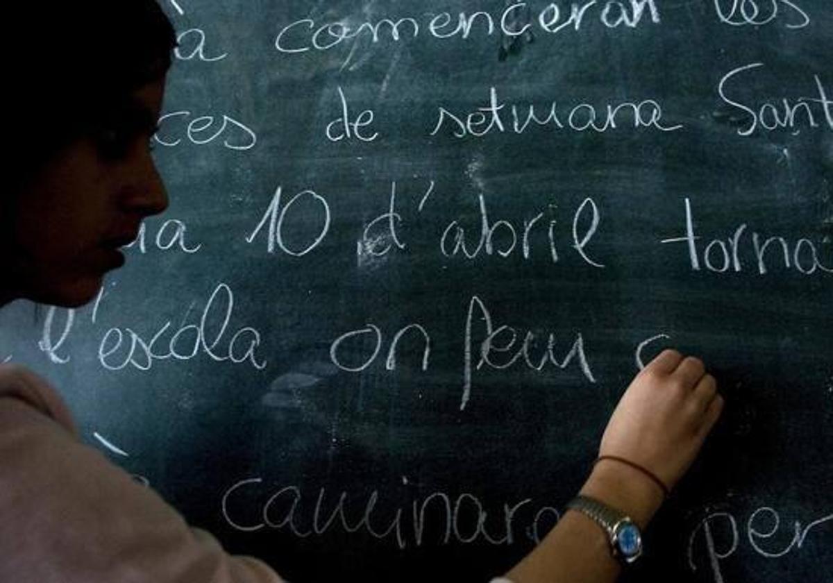 Un alumno escribe en una pizarra.