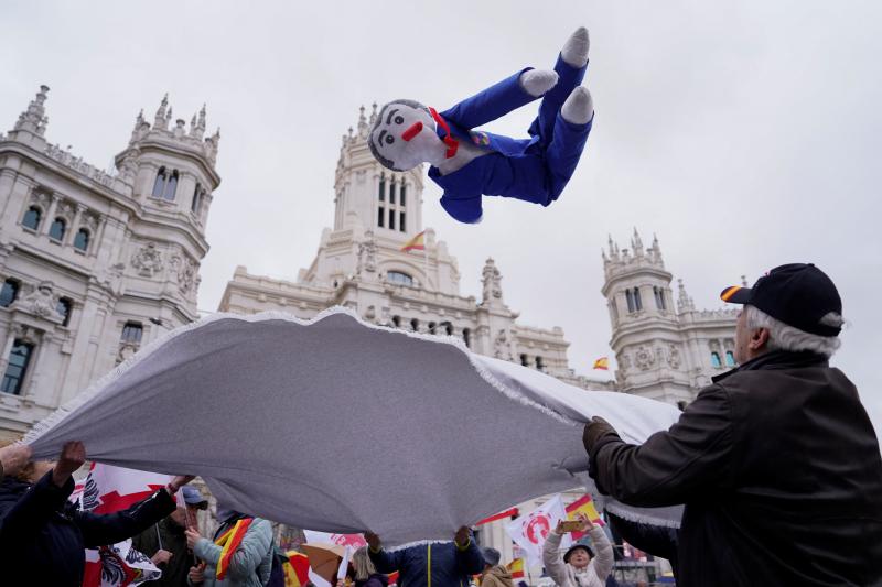 Un grupo de personas mantea un muñeco de Pedro Sánchez.