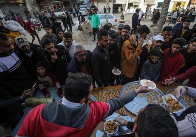 La gente se arremolina en una calle de Rafah ante los puestos de venta de comida.