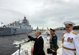 Putin preside un desfile naval en San Petersburgo, acompañado por el ministro de Defensa, Sergei Shoigu, y el cesado almirante Nikolai Yevménov.