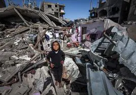 Una niña palestina mira al cielo entre escombros en el campo de refugiados de Rafah.