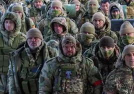 Un grupo de voluntarios reclutados por las Fuerzas Armadas rusas esperan en el aeropuerto de Grozni.