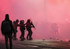 Agentes de la Ertzaintza se protegen ante el lanzamiento de objetos por parte de los ultras del Athletic en los aledaños de San Mamés.
