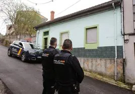 Dos agentes de la Policía Nacional custodian la vivienda de la calle Joaquín Costa, en La Felguera, en la que se produjo el crimen.